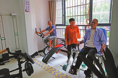 残疾人综合服务中心工作人员鄢光菊正在指导残疾老人健身